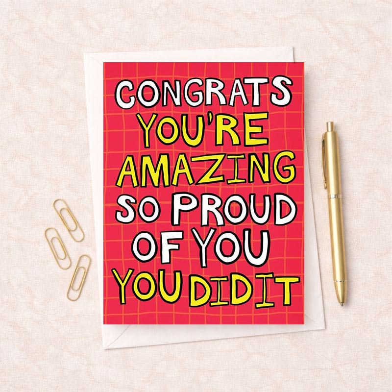 Pink greetings card with message: "CONGRATS YOU'RE AMAZING SO PROUD OF YOU YOU DID IT" - perfect for celebrating achievements.