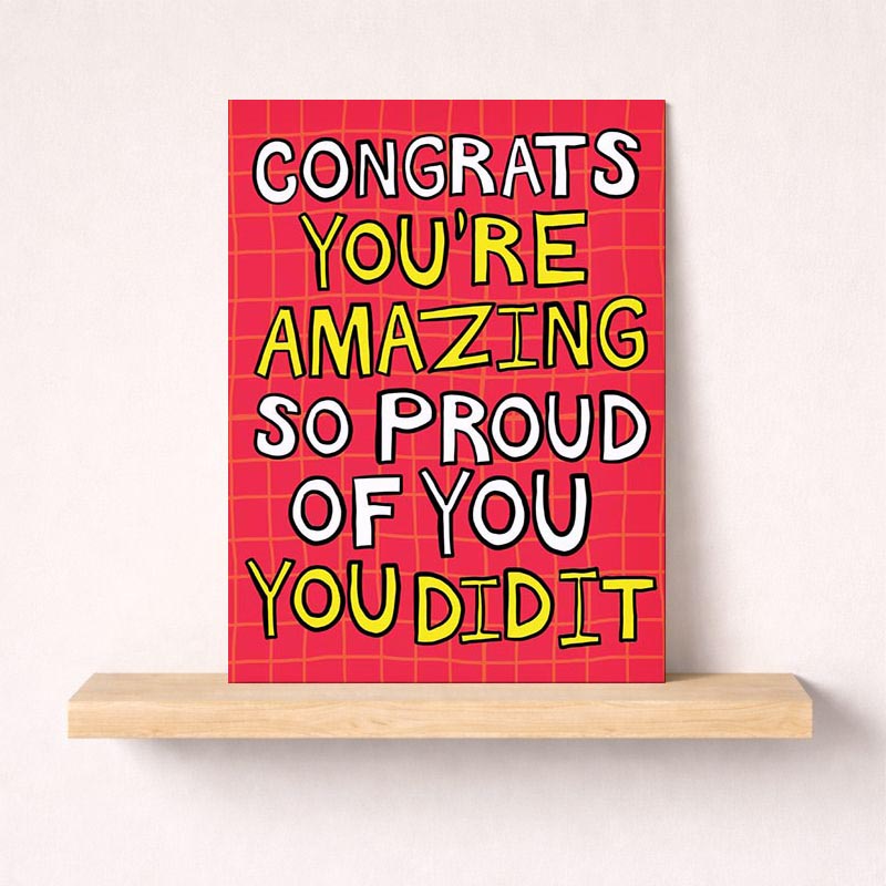 Pink greetings card with message: "CONGRATS YOU'RE AMAZING SO PROUD OF YOU YOU DID IT" - perfect for celebrating achievements.