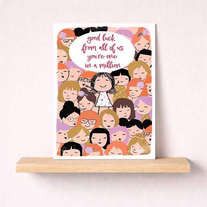 A4 greetings card with girl surrounded by well-wishers, speech bubble says "good luck from all of us in a million.