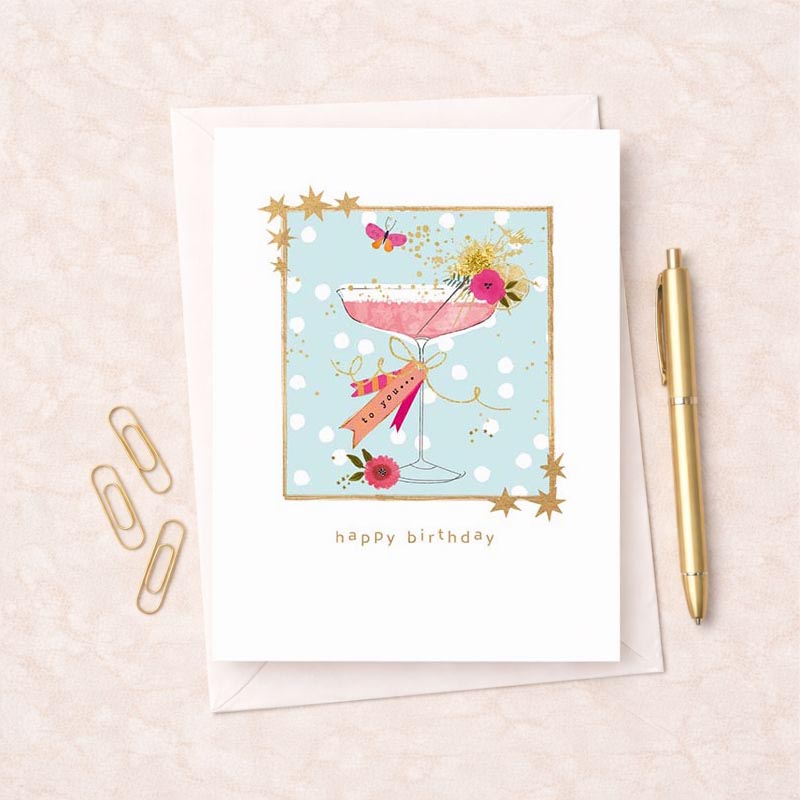 Vibrant birthday card with pink cocktail glass and ribbon, exuding joy and cheers. Perfect for celebrating with elegance and glamour.