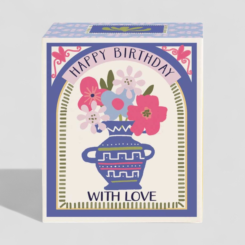 Lit yellow candle in glass with happy birthday and with love gift box.