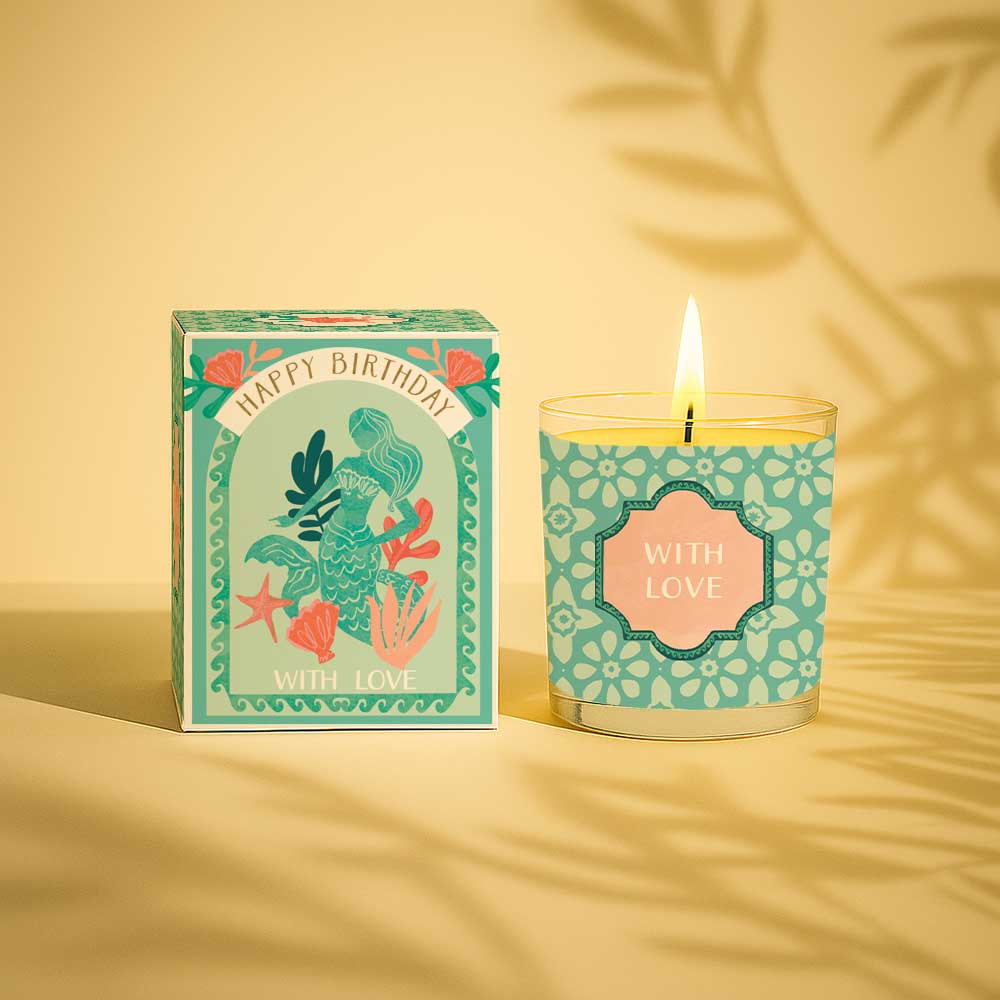 Lit yellow candle in a glass with happy birthday gift box and with love label