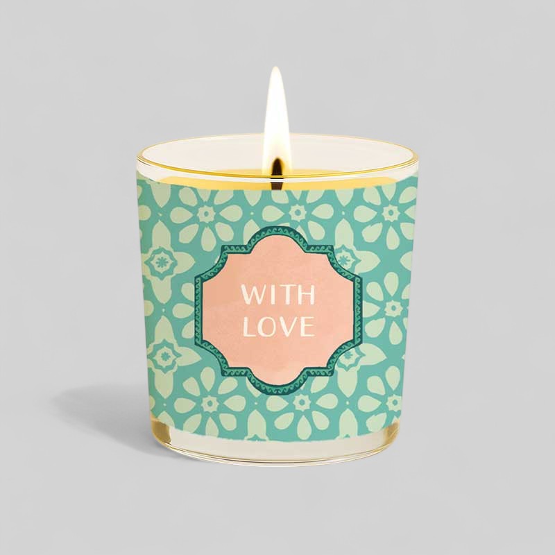 Lit yellow candle in a glass with happy birthday gift box and with love label