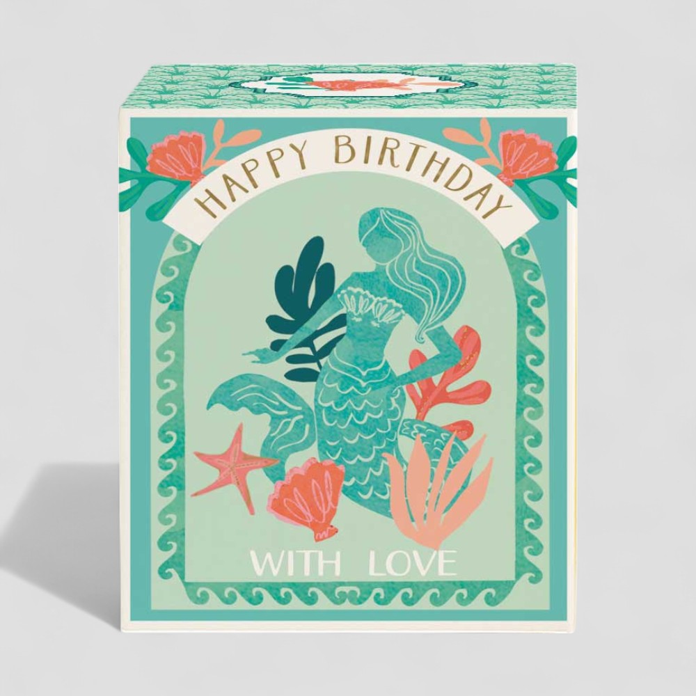 Lit yellow candle in a glass with happy birthday gift box and with love label