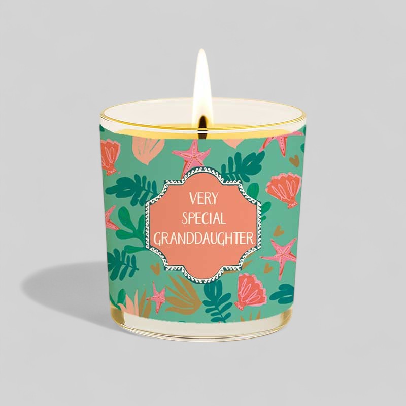 Lit yellow candle and matching box with floral design and text Very Special Granddaughter