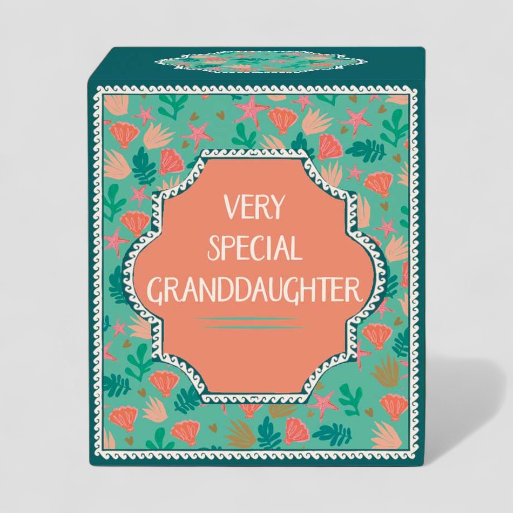 Lit yellow candle and matching box with floral design and text Very Special Granddaughter