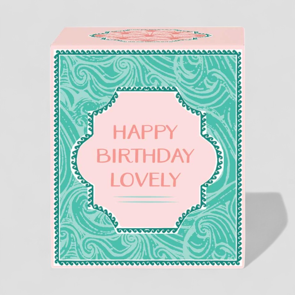 Lit yellow candle in glass with happy birthday lovely message and matching gift box