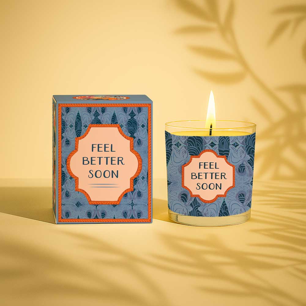 Lit yellow candle with feel better soon label and matching blue box