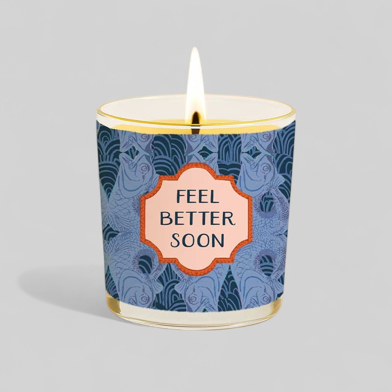 Lit yellow candle with feel better soon label and matching blue box