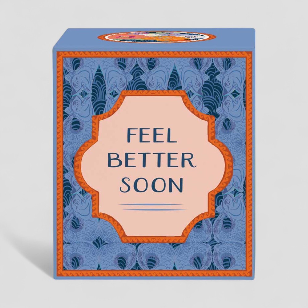 Lit yellow candle with feel better soon label and matching blue box