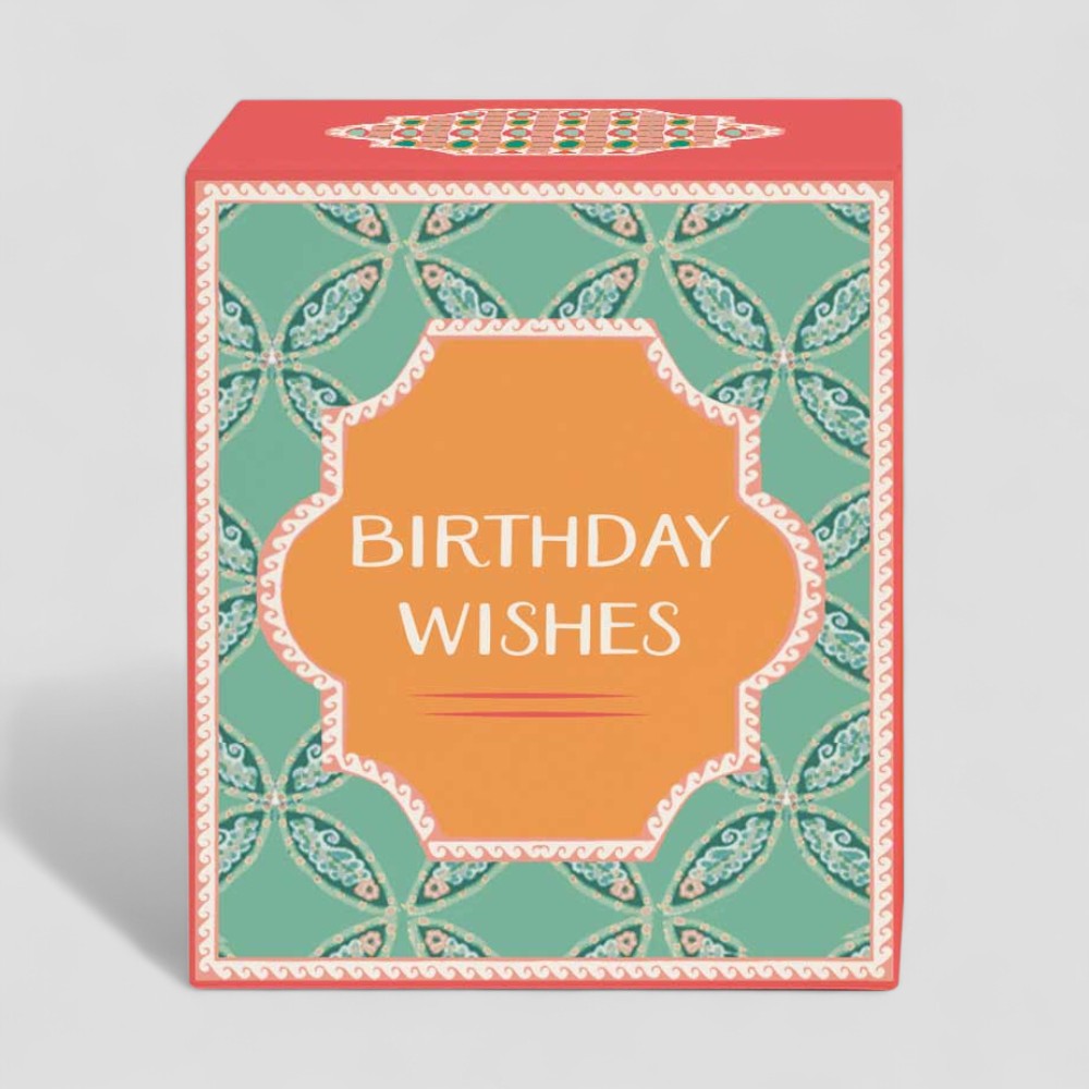 Lit yellow candle in glass with birthday wishes packaging and label