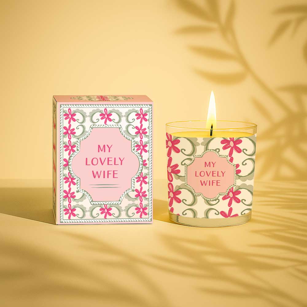 Lit yellow candle with floral design and text My lovely wife on glass and box