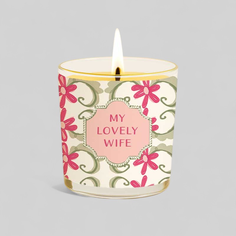 Lit yellow candle with floral design and text My lovely wife on glass and box