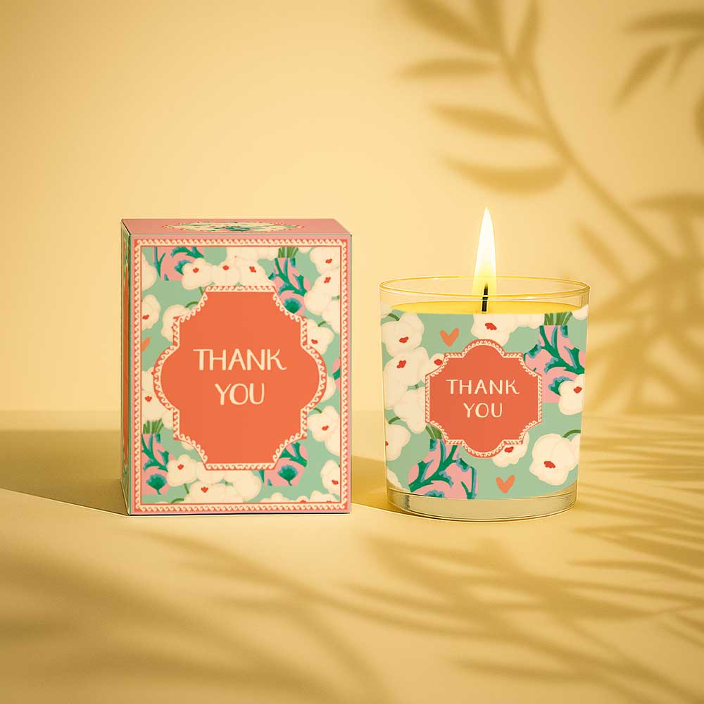 Lit yellow candle with thank you label and matching floral gift box