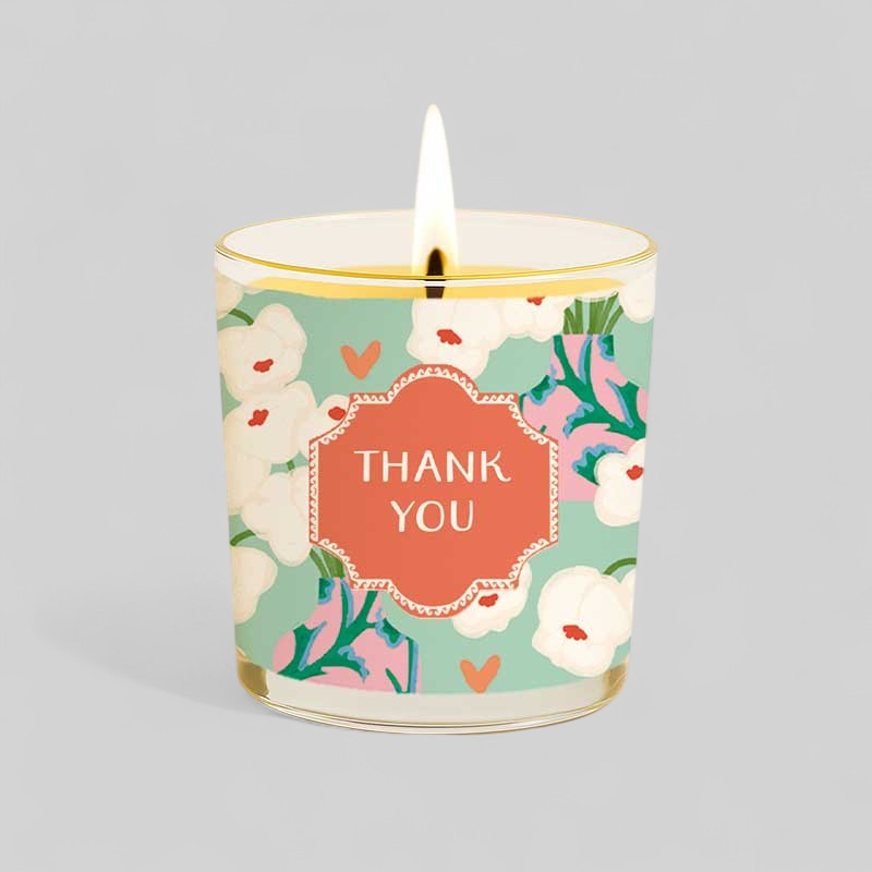Lit yellow candle with thank you label and matching floral gift box