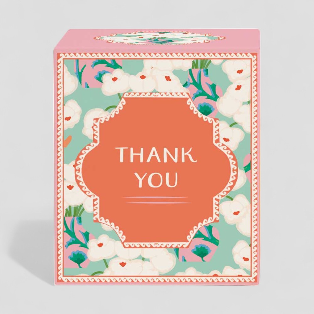 Lit yellow candle with thank you label and matching floral gift box