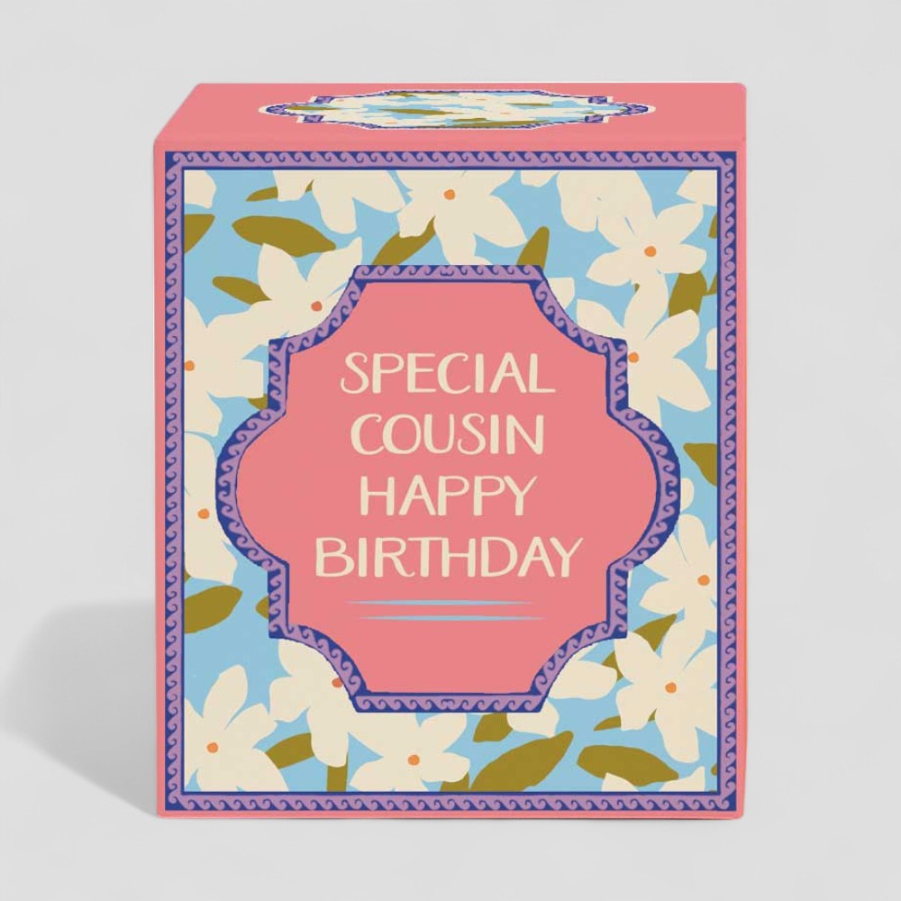 Lit yellow candle with floral packaging saying special cousin happy birthday