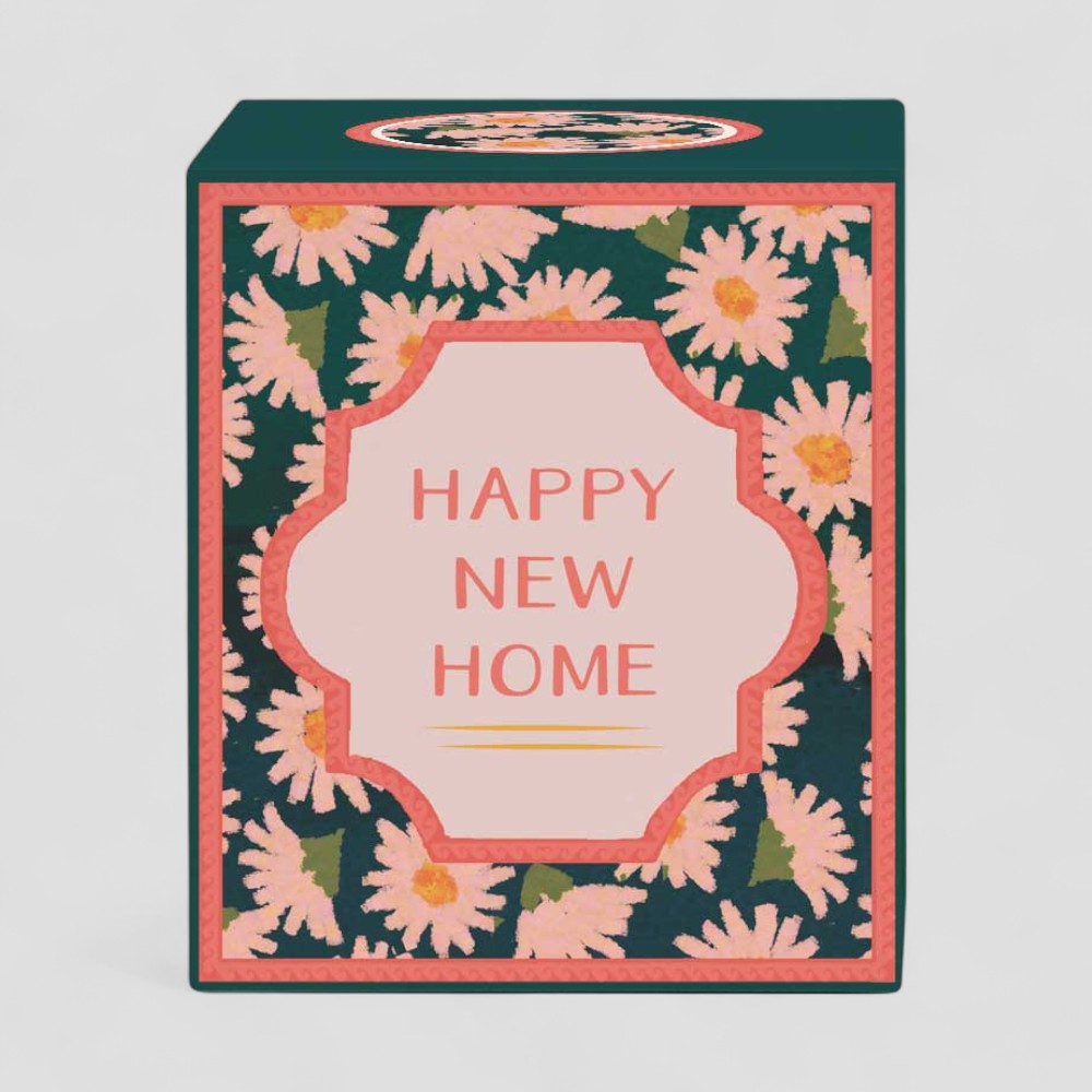 Lit yellow candle with floral Happy New Home label and matching gift box
