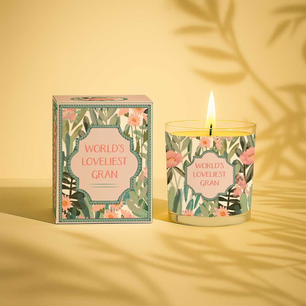 Lit yellow candle and box with floral design and text Worlds Loveliest Gran