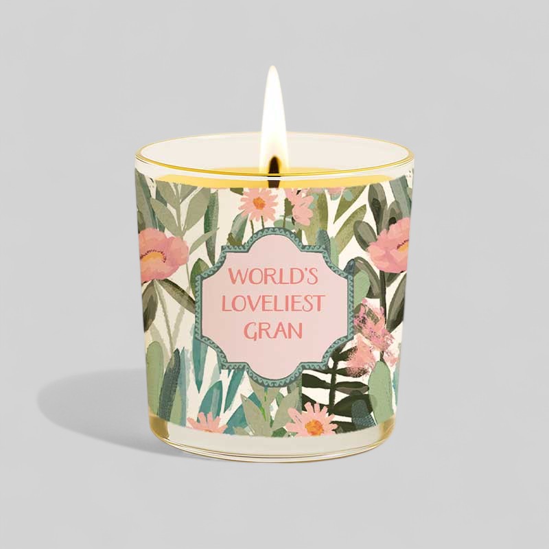 Lit yellow candle and box with floral design and text Worlds Loveliest Gran
