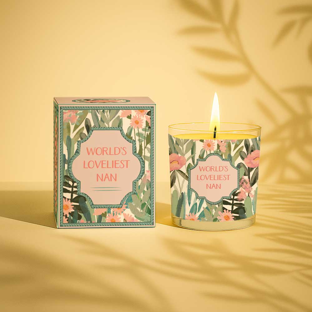 Lit yellow candle beside floral box labelled Worlds Loveliest Nan gift set
