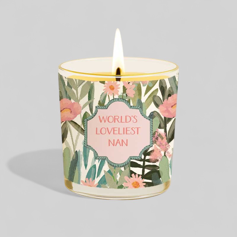 Lit yellow candle beside floral box labelled Worlds Loveliest Nan gift set