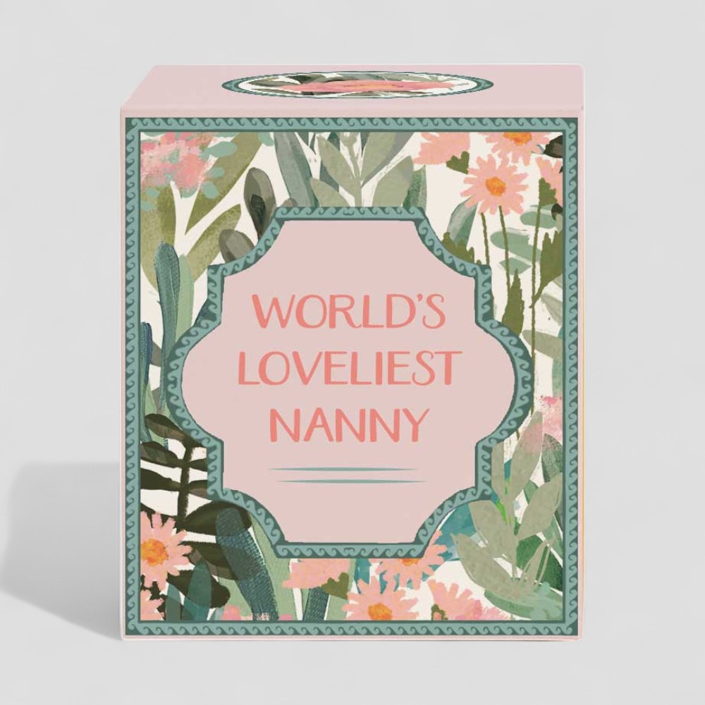 Lit yellow candle and box with floral design and text Worlds Loveliest Nanny