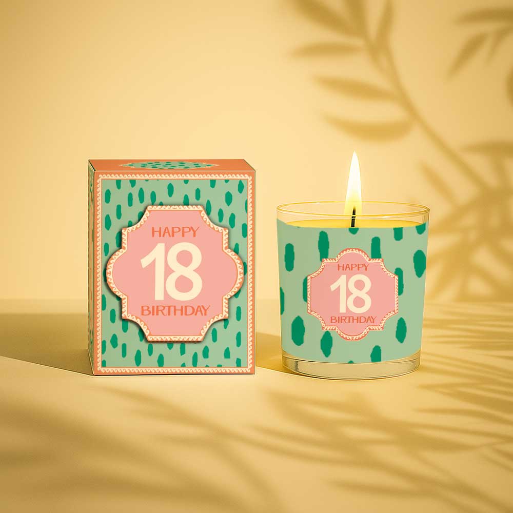 Lit yellow candle and box with Happy 18th Birthday design on pale blue background