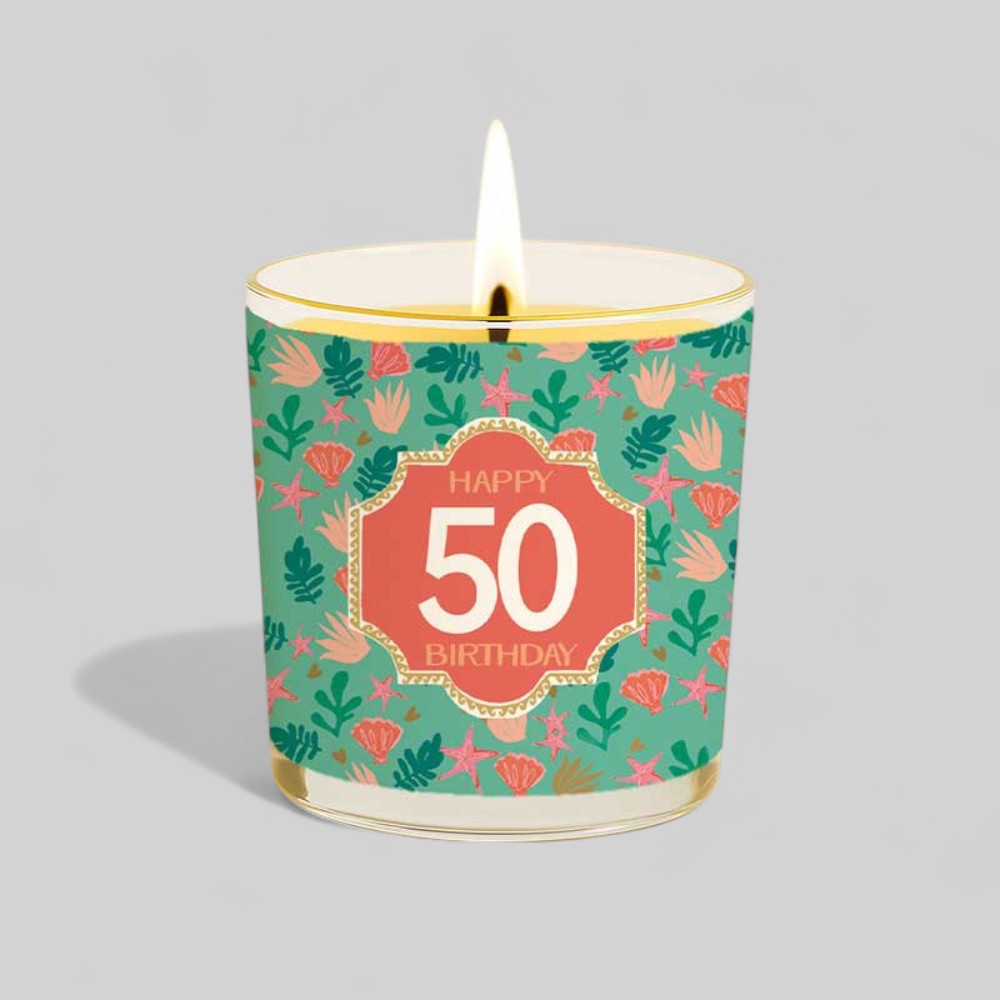 Lit yellow candle in glass with happy 50th birthday floral design and matching box