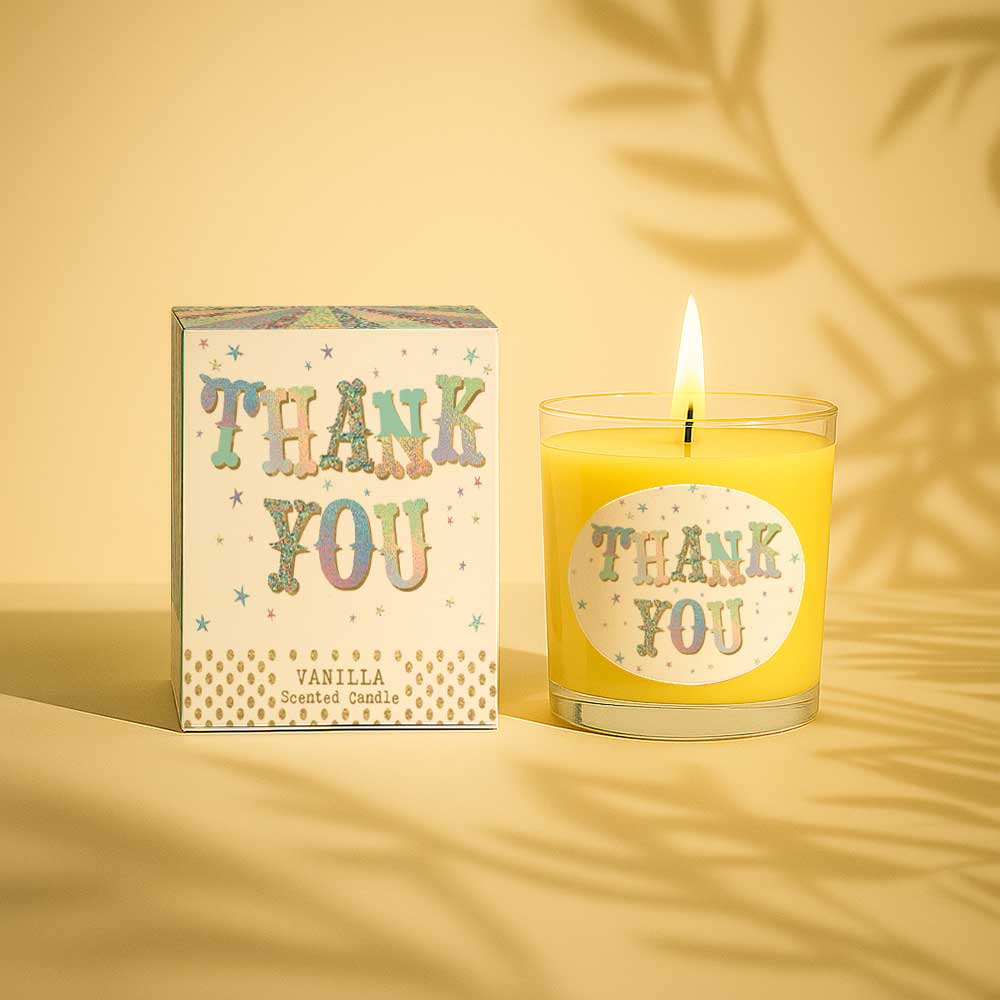 Vanilla scented candle lit with thank you label next to matching thank you box