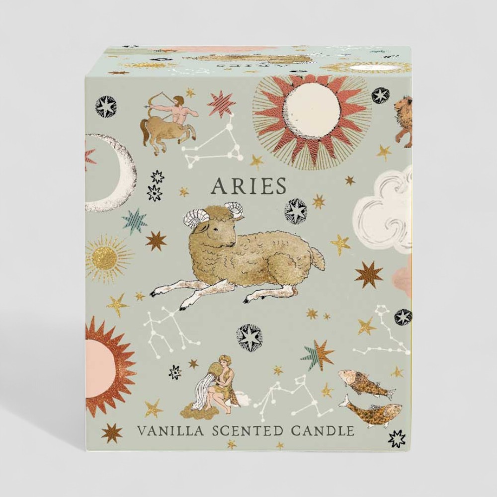 Lit Aries vanilla scented candle next to its decorative box with zodiac design