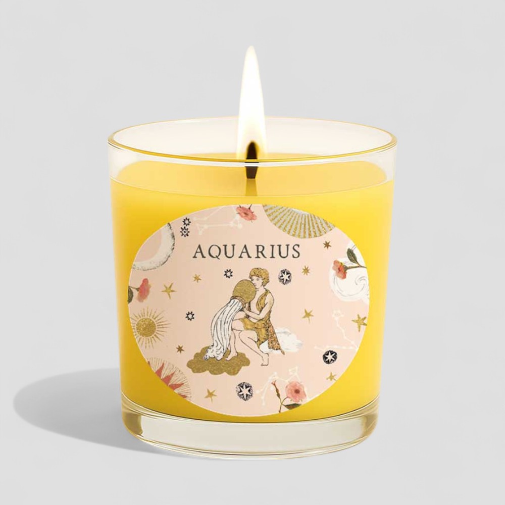 Aquarius vanilla scented candle with zodiac design on box and glass holder lit flame