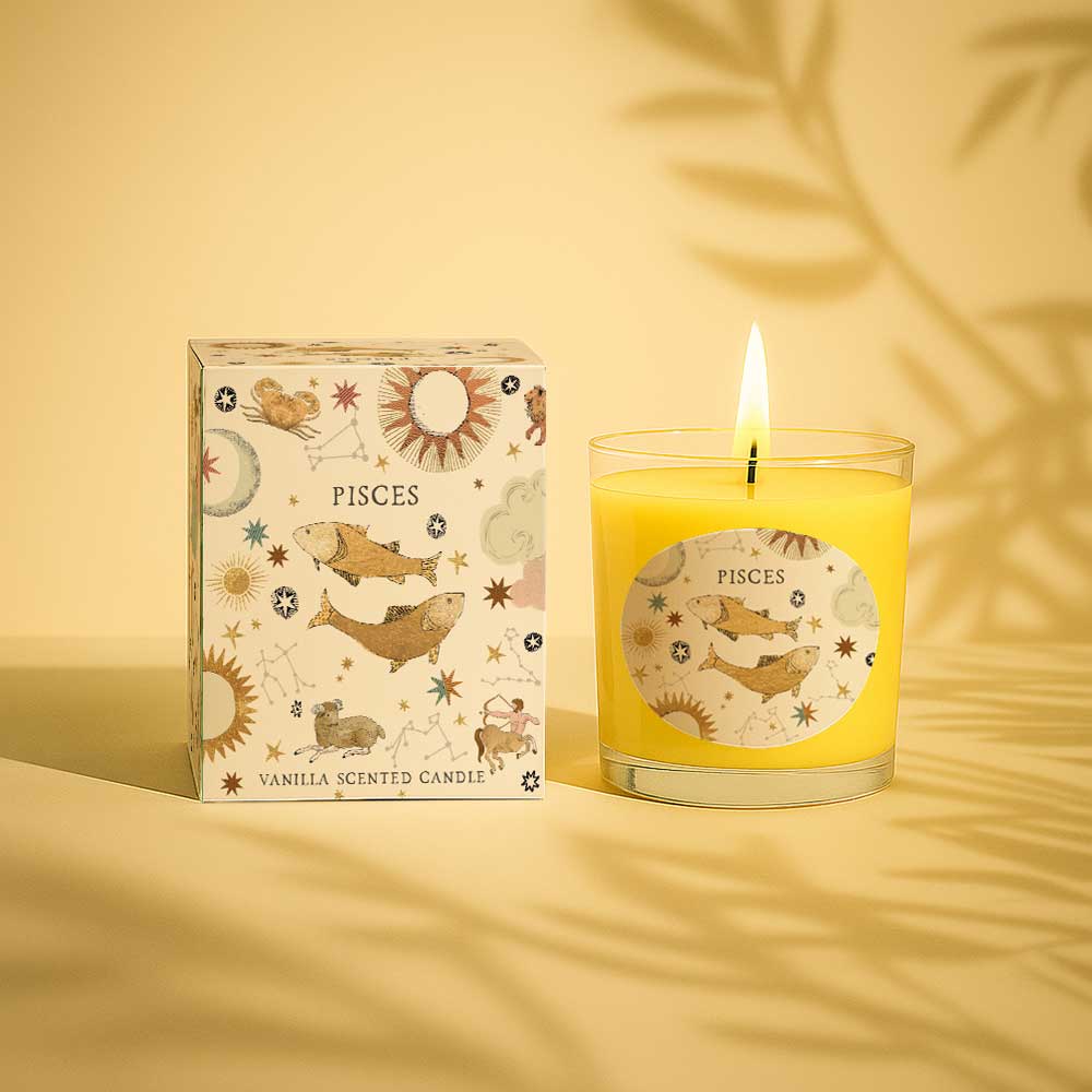 Lit vanilla scented candle in glass with Pisces zodiac sign and matching box