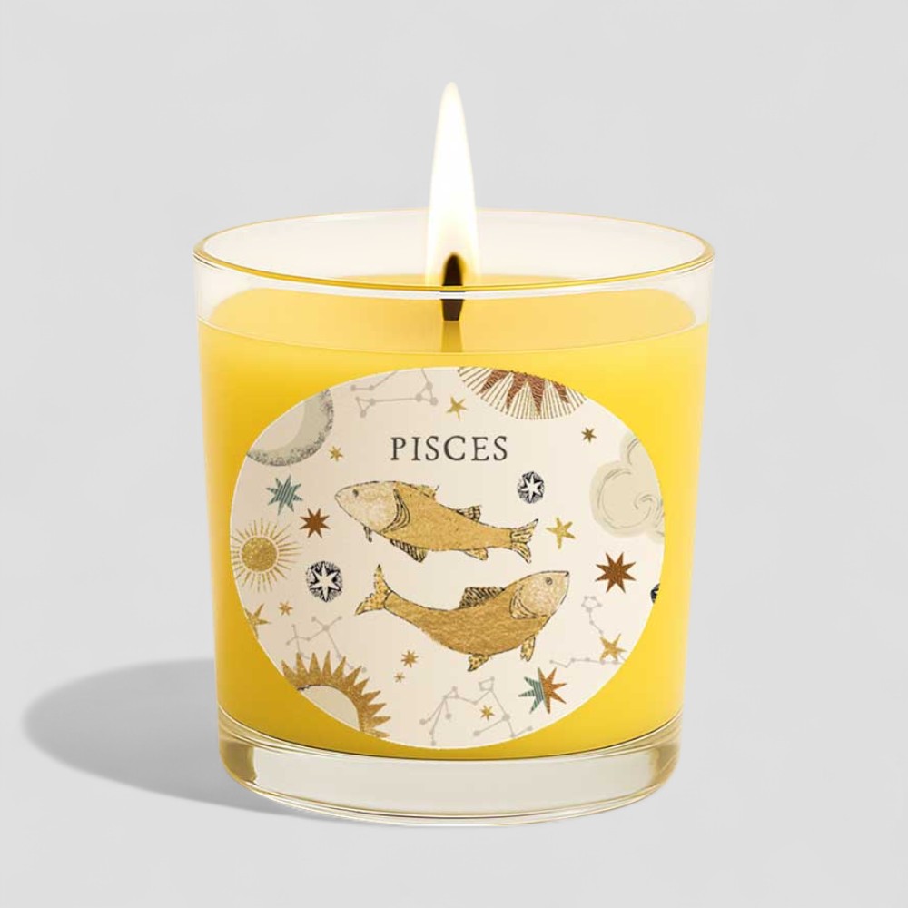 Lit vanilla scented candle in glass with Pisces zodiac sign and matching box