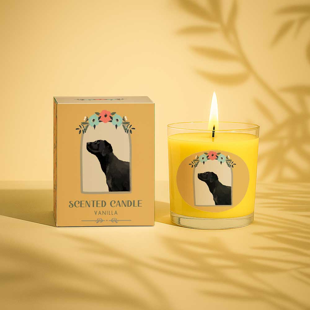 Lit vanilla scented candle in glass with black dog and floral design on box and label