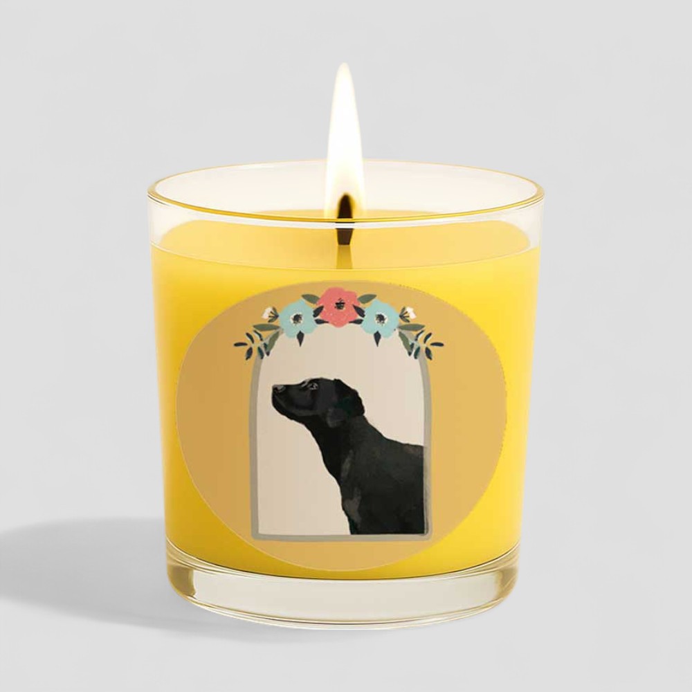 Lit vanilla scented candle in glass with black dog and floral design on box and label