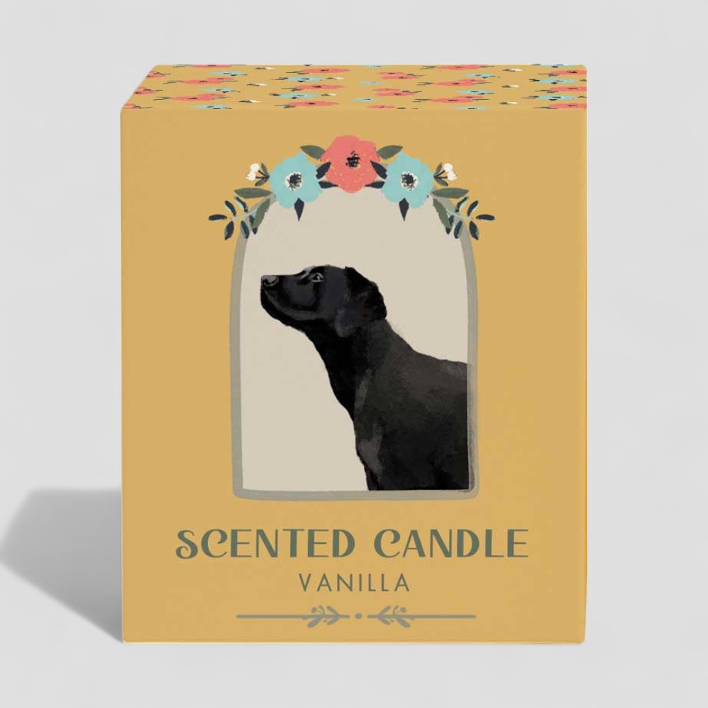 Lit vanilla scented candle in glass with black dog and floral design on box and label