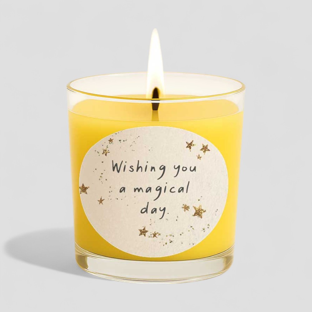 Lit vanilla scented candle with wishing you a magical day message and decorative box.