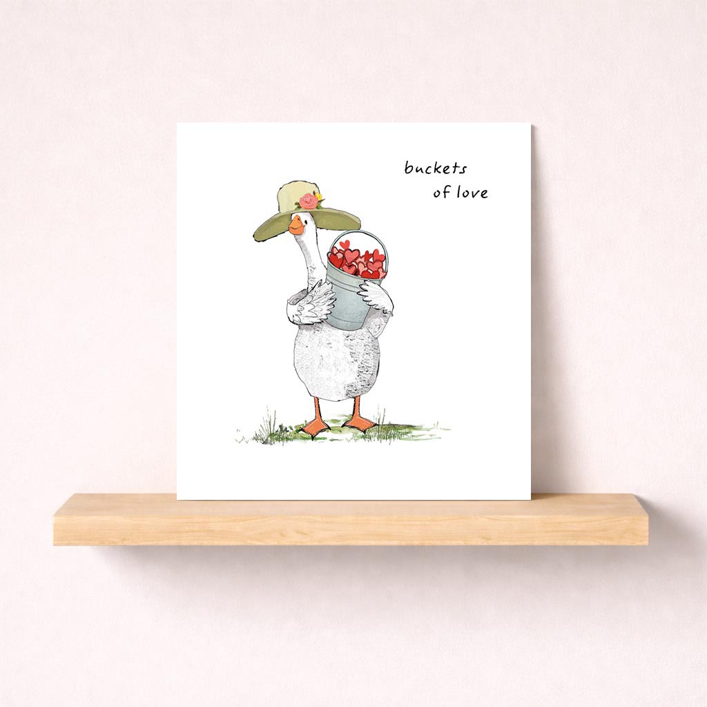 A cute duck with flowers in a bucket on a greetings card, perfect for spreading love and cheer. Ideal for any occasion to bring a smile to someone's face.