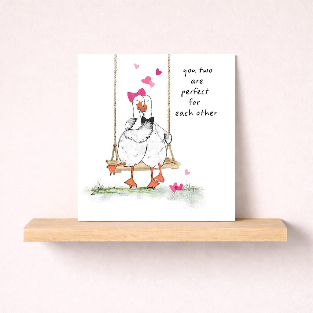 Sweet and charming greetings card with ducks on swing surrounded by hearts, perfect for expressing love and affection.