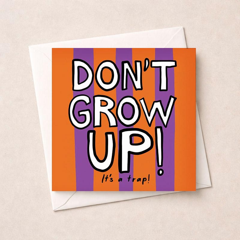 Colorful card with bold text saying "DON'T GROW UP! It's a trap!" against purple and orange background. Perfect for birthdays or graduations.