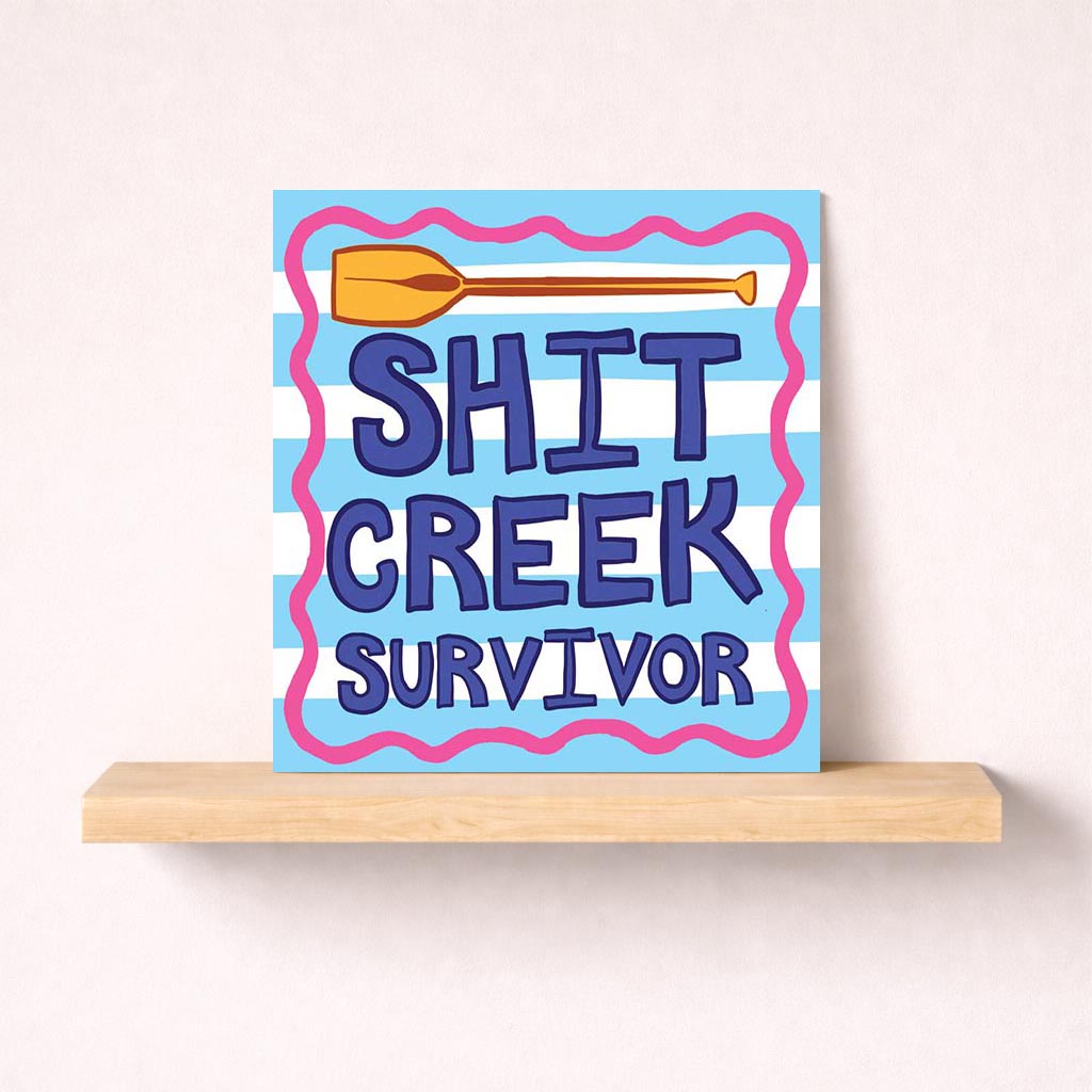A blue and white striped greetings card with a paddle and "Shift Creek Survivor". Perfect for celebrating resilience and strength.