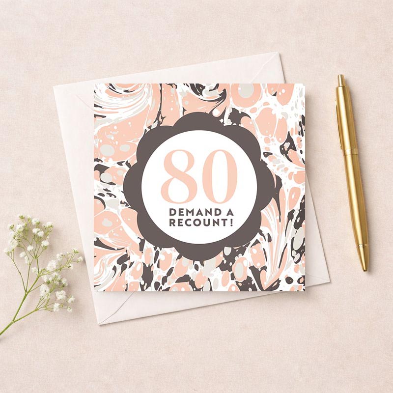 Humorous 80th birthday card with floral background and bold sign saying "80 DEMAND A RECOUNT!