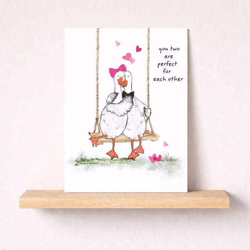 Two cute ducks on swing surrounded by hearts, perfect for expressing love and friendship. Ideal for birthdays, anniversaries, or just to say hello.