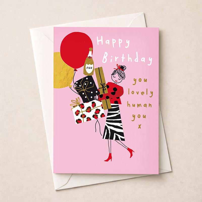 A vibrant greetings card with a woman holding a red balloon and gift, saying "Happy Birthday, you loved human you". Spread cheer to loved ones.