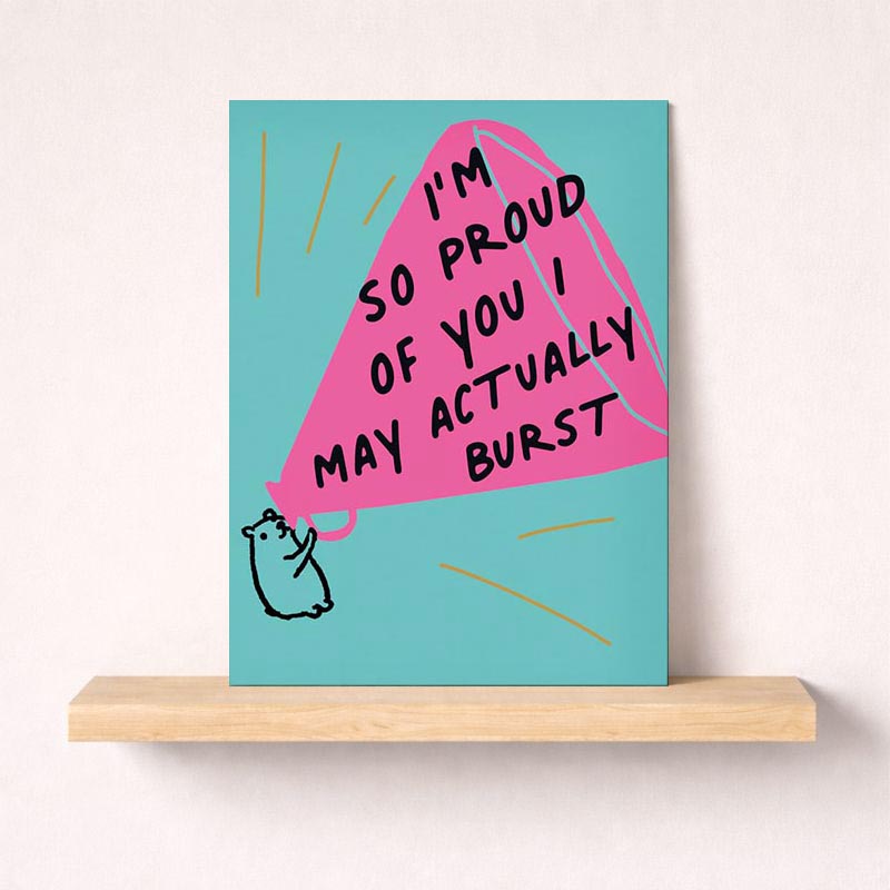 A happy man holding a pink kite on a blue background with the message "I'm so proud of you" on a greetings card. Ideal for showing support and encouragement.