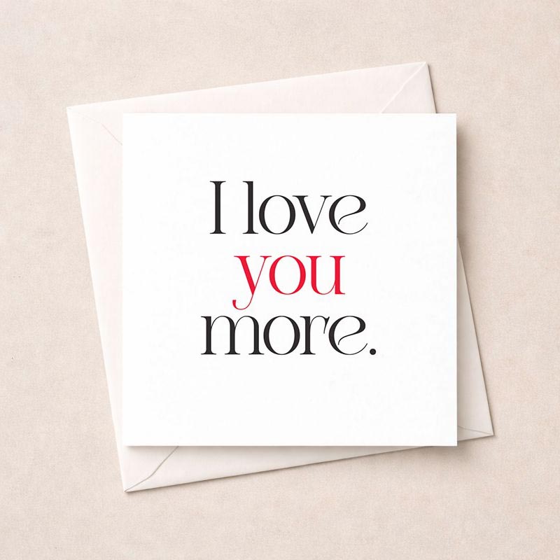 A black and white greetings card with "I love you more" in elegant typography, perfect for expressing deep affection to a special someone.