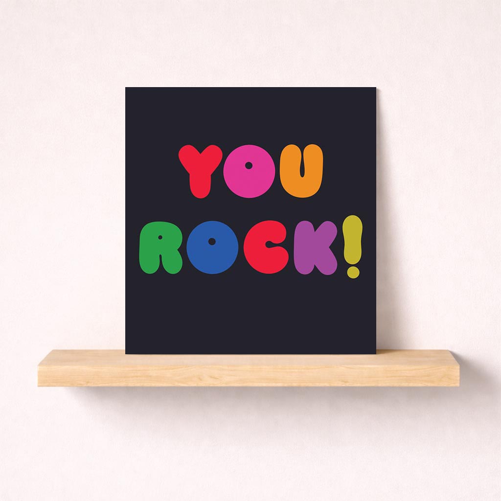 Vibrant card with "ROCK!" in colorful text on black background. Positively encourages recipient, perfect for cheering someone up.