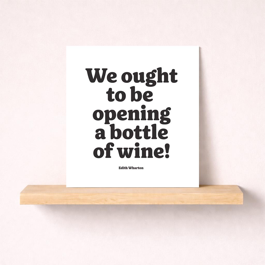 Elegant black and white greetings card with quote "We ought to be opening a bottle of wine! Edith Wharton" - perfect for wine lovers.