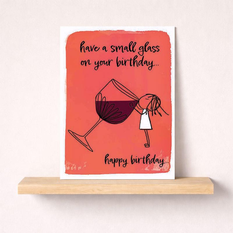 A girl holding a glass of wine on a birthday greetings card.